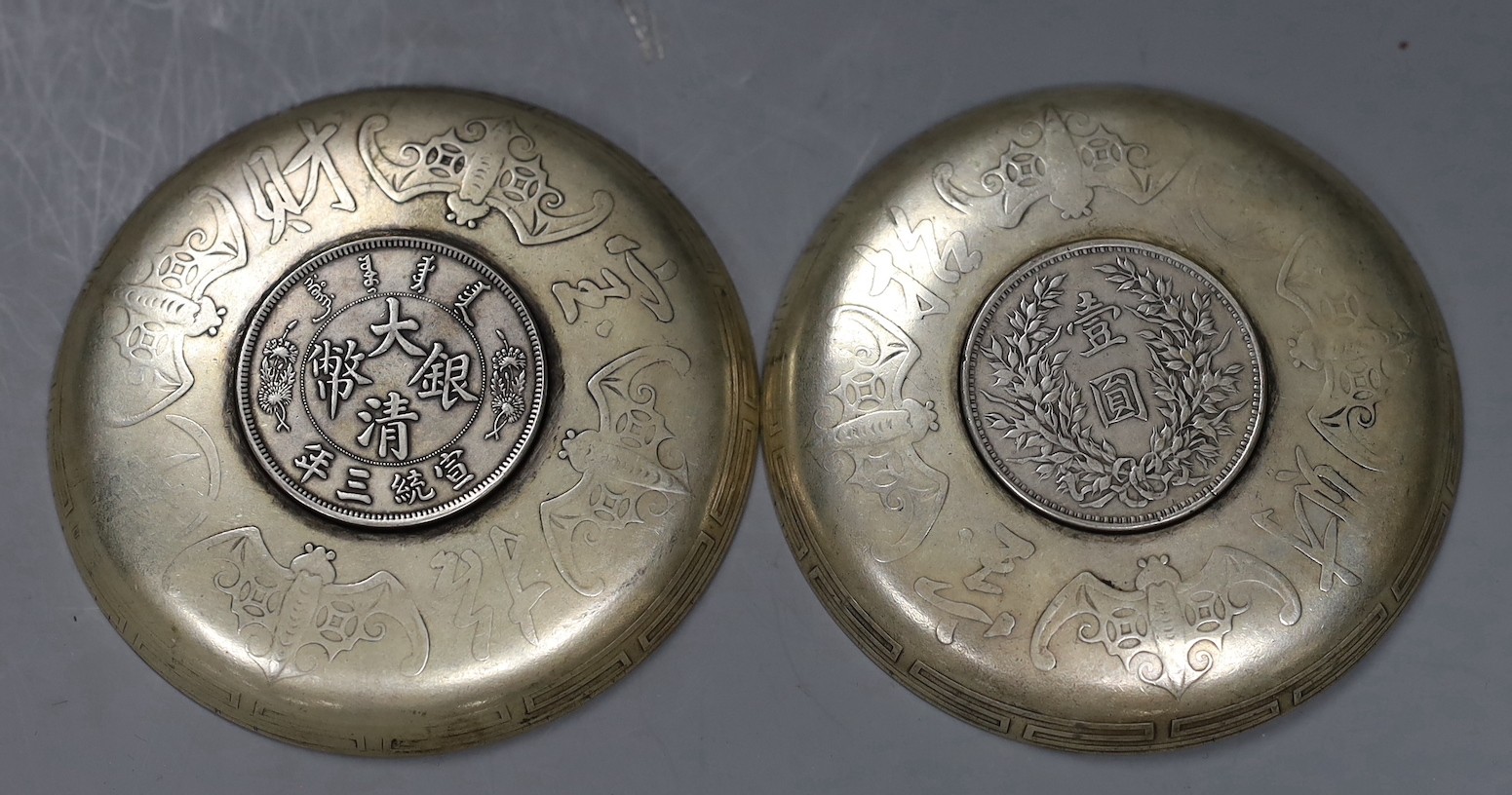 A pair of Chinese coin inserted dishes, 9cms diameter
